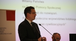 Zdjęcie przedstawia osobę przemawiającą przy mównicy podczas Forum Pomocy Społecznej